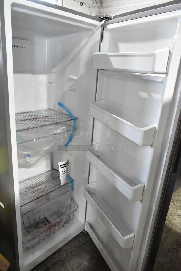 Frigidaire FFFU13F2VV upright freezer, 13.0 cu. ft. capacity, open door view, multiple shelves, new condition, Energy Guide tag.