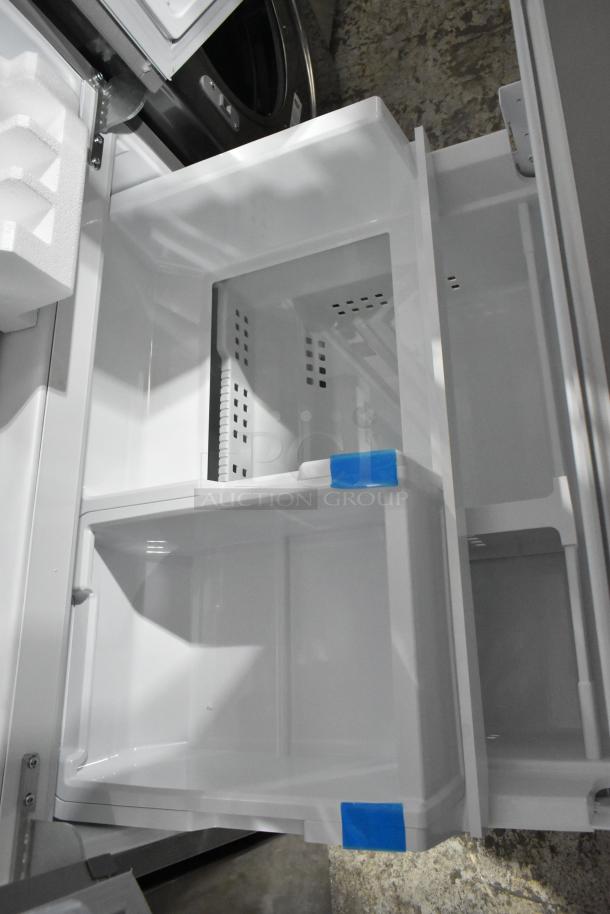 Brand new Frigidaire GRFS2853AFL French door cooler, visible interior shelving and compartments, minor scratches and dents.