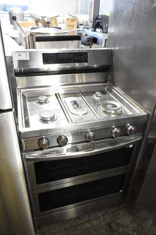 Gas-powered 4 burner range with 2 ovens, stainless steel, missing grates, panel controls visible, model label included.