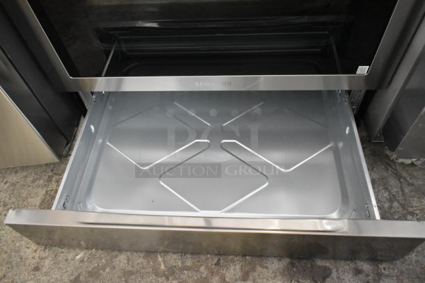 Gas-powered 4 burner range with 2 ovens, missing grates. Samsung brand visible on open oven drawer.