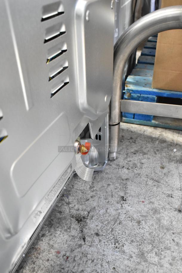 Gas powered 4 burner range with 2 ovens, missing grates, in fair condition. Ventifacts and instructions partly visible.