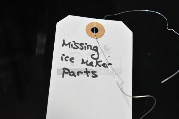 White tag with handwritten note: "Missing ice maker parts," attached to a Frigidaire Gallery SEE26NVDDA cooler/freezer.