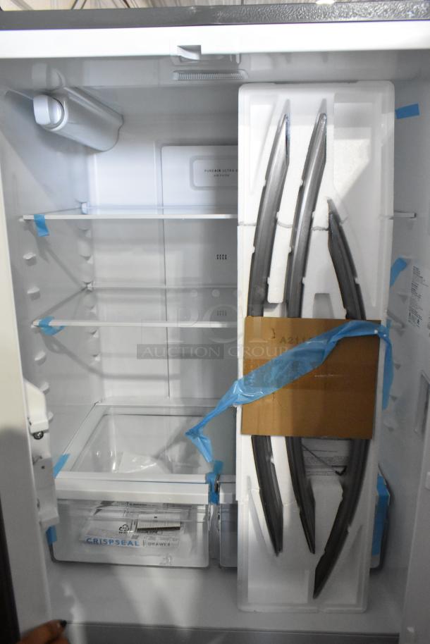 Brand new Frigidaire FRFG1723AV04 reach-in cooler with freezer. Visible storage shelves, crisp seal drawer, and packaging.