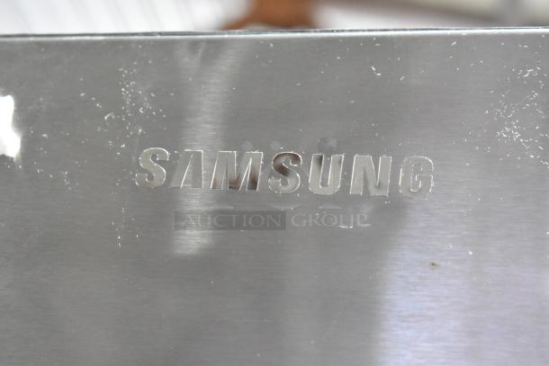 Samsung logo on the 2023 RF32CG5400SR French Door Cooler. Scratch and dent condition shown on the surface.