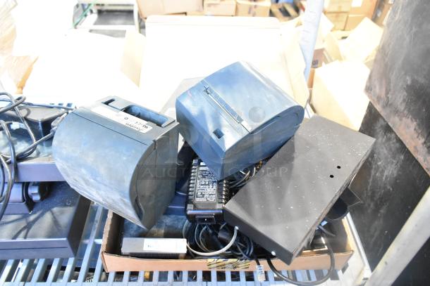 Auction lot with a POS monitor, several receipt printers, and assorted wires in used condition. Labels show power specs.