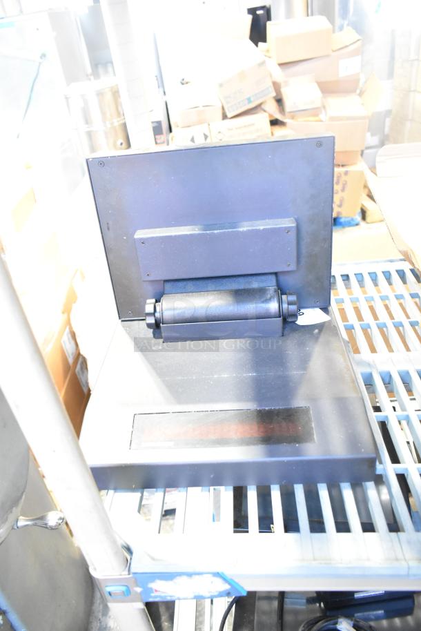 10-item lot with POS monitor, receipt printers, and wires. Includes various office electronics. Items visible in warehouse setting.