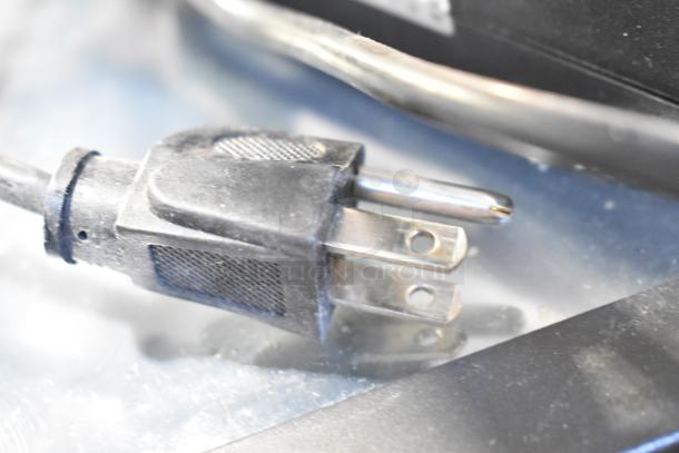 Alt text: Assorted electronics including a power plug, part of a lot with POS monitor, receipt printers, and cables.