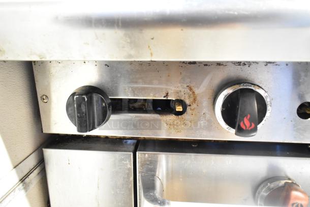 Close-up of control knobs on a 2016 American Range AR-6 commercial natural gas 6-burner range, showing wear and grime.