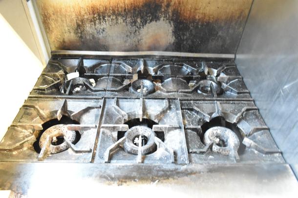 2016 American Range AR-6 commercial gas range with 6 burners, oven, overshelf, and backsplash, showing signs of use.