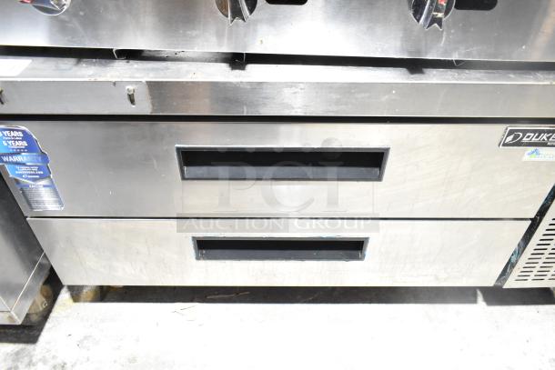 Dukers DCB48 chef base with 2 drawers on casters. Stainless steel finish, 115 volts, 1 phase. Warranty sticker visible.