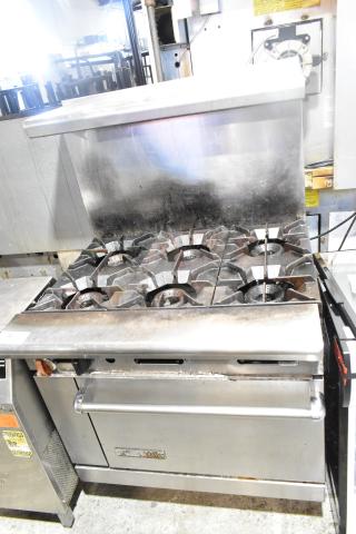 American Range commercial 6 burner gas range with oven, overshelf, and backsplash. Used condition, stainless steel exterior.