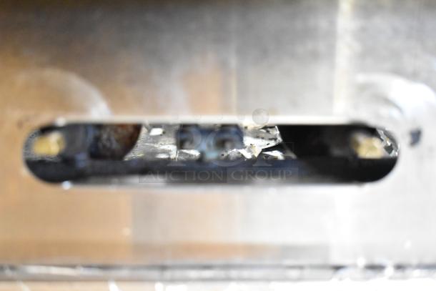 Close-up of the American Range Commercial 6 Burner Gas Range interior, showing wear and maintenance details.