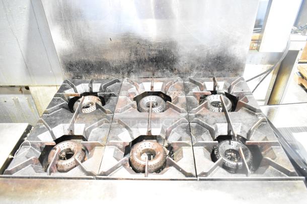 American Range commercial gas-powered 6 burner range with oven, over shelf, and backsplash; shows moderate wear.