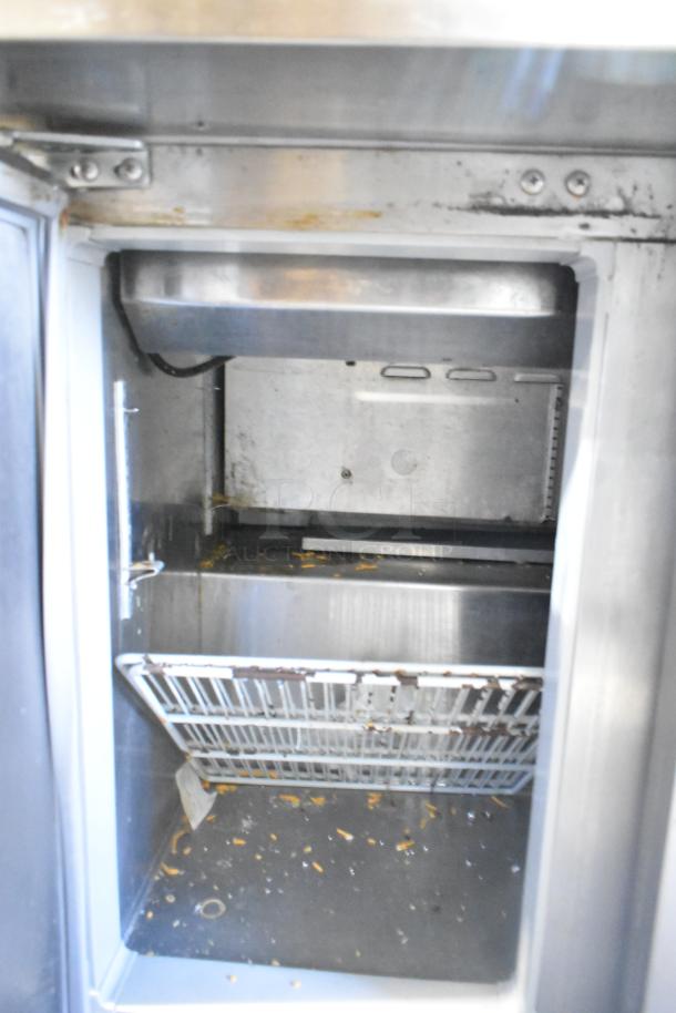 Continental DL36-15M sandwich salad prep table, interior view, showing stainless steel construction; appears used with debris.