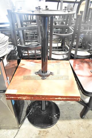 Two dining height tables with wood pattern tops, metal bases. Visible wear and scratches. Auction tag reads "82".