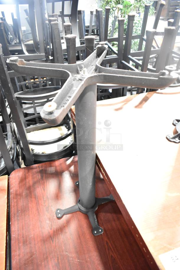 Two dining height tables with black tabletops and metal bases, stacked, showing sturdy construction.