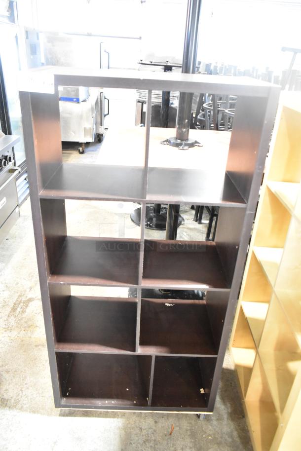 Dark wood bookshelf with four shelves and a grid design. Visible wear on edges. Ideal for storage or display.