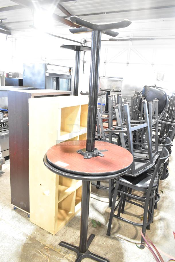 Two bar height tables with black tabletops and metal bases, in used condition, suitable for auctions; bid doubles.