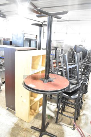 Two bar height tables with black tabletops and metal bases, in used condition, suitable for auctions; bid doubles.