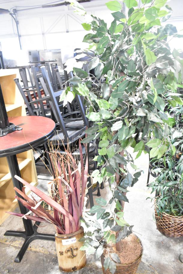 Two fake plants in baskets; one with green foliage, the other with purple leaves. Good condition for decor use.