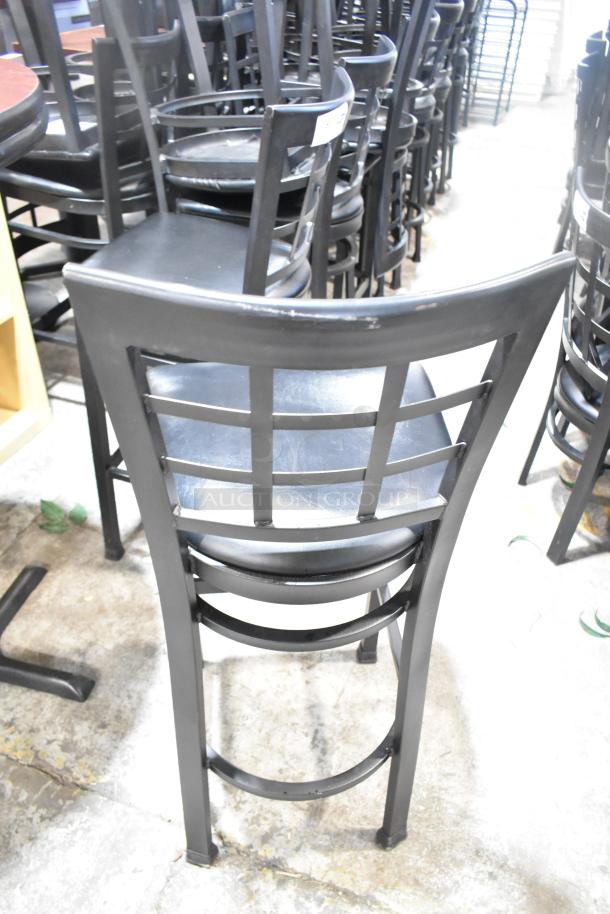 37 black bar height chairs with window back design, black seat cushions. Good condition, ideal for restaurant use.