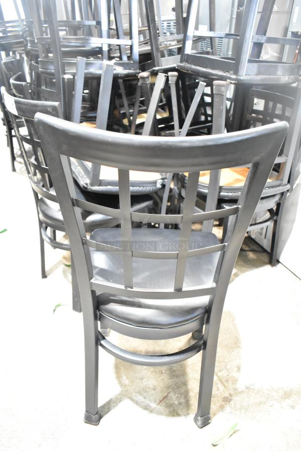 Black window back dining chairs with black seat cushions, stacked. 36 chairs available in good condition.