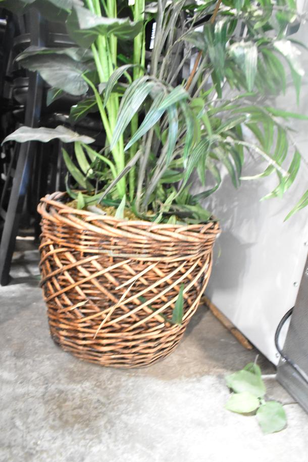 Two fake plants in woven baskets, with green foliage and realistic detailing, perfect for home décor.