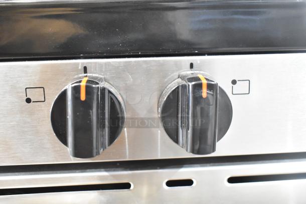 Frigidaire FCRG3052BSF gas range knob close-up. Stainless steel, dual control. Auction item in good condition.