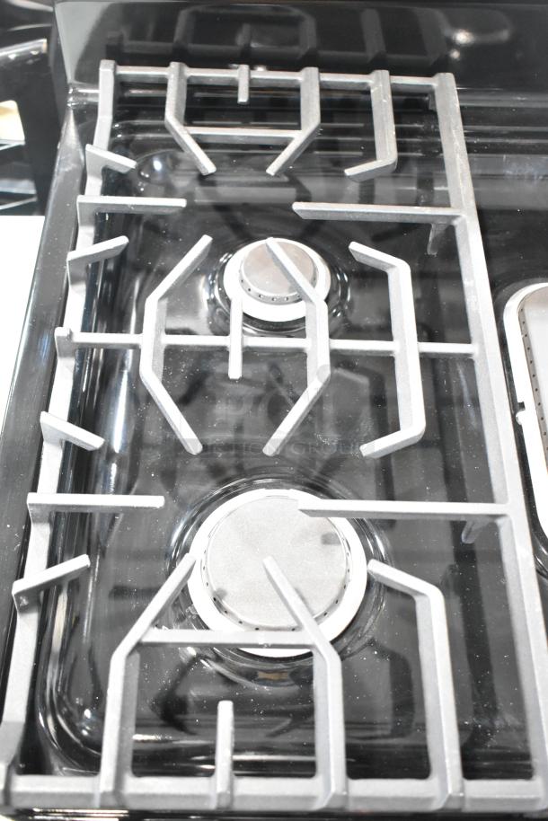 Frigidaire FCRG3052BSF natural gas range with 4 burners, sleek design, metal grate, black finish, excellent condition.