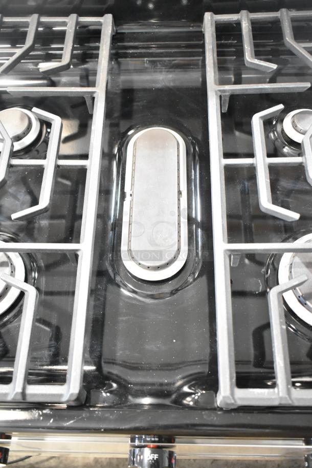 Frigidaire FCRG3052BSF natural gas range, 4 burners, sleek design, visible burner grates, excellent condition.