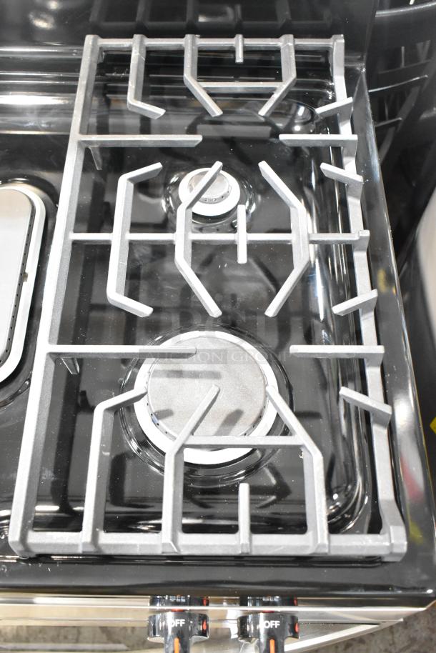 Frigidaire FCRG3052BSF gas range with 4 burners, black finish, visible control dials, and stainless steel grates, excellent condition.