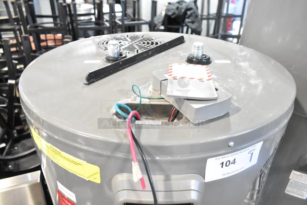 Rheem hot water heater, 208/240 volts, gray finish. Visible wiring and inspection labels. Ideal for home use.