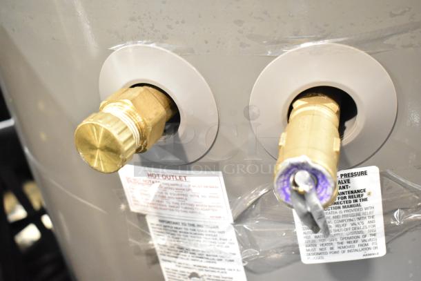 Rheem hot water heater with brass fittings, 208/240 volts, labeled for hot outlet and pressure valve. New condition.