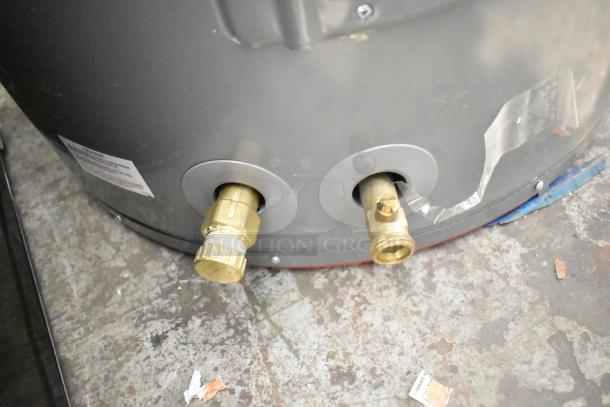 Rheem hot water heater, 208/240 volts, in good condition with brass fittings visible. Label indicates operational details.