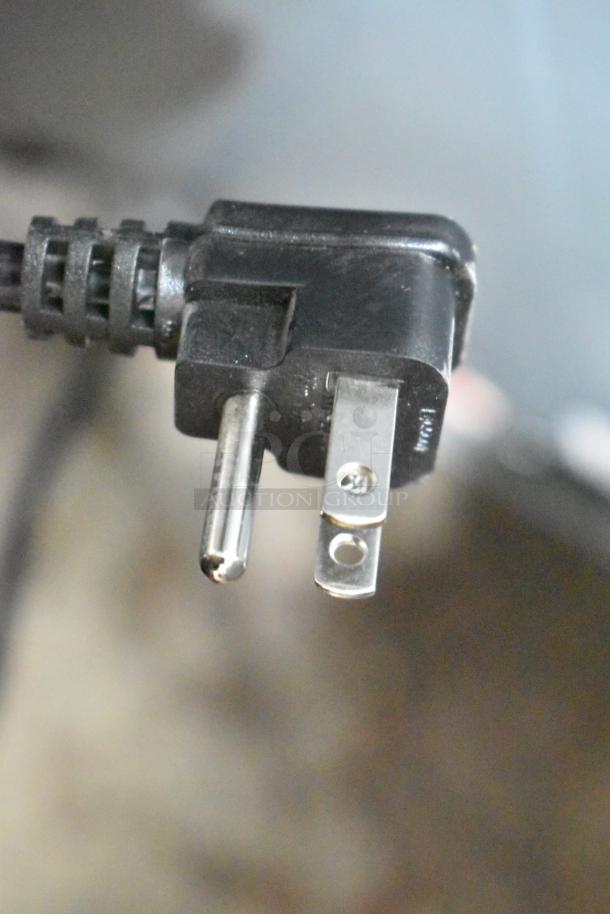 Close-up image of a three-prong electrical plug, part of the Vissani MDTF14WH5 cooler with freezer. 115 volts, 1 phase.