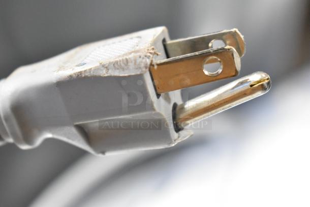 Close-up of a plug with minor scuff marks on the edge. Associated with Samsung WF45B6300AW/US front load washer.