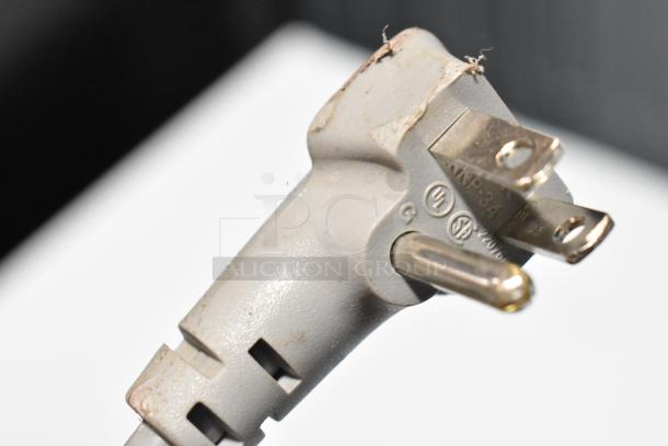 Close-up of a three-prong plug for LG LRFXC2606S/00 refrigerator, showing wear and markings.