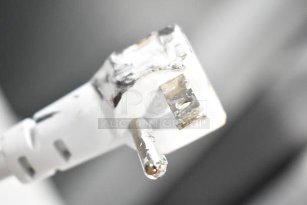 Close-up image of a damaged white electrical plug, showing bent prongs and scuff marks.