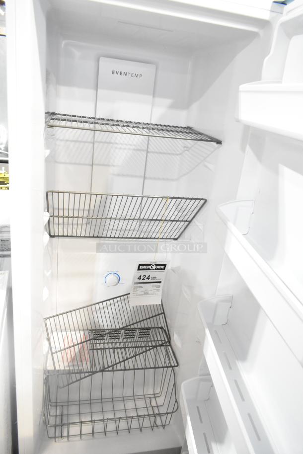 Brand new Frigidaire FFFU13F2VW upright freezer, scratch and dent. Features wire shelves, energy guide shows 424 kWh/year.