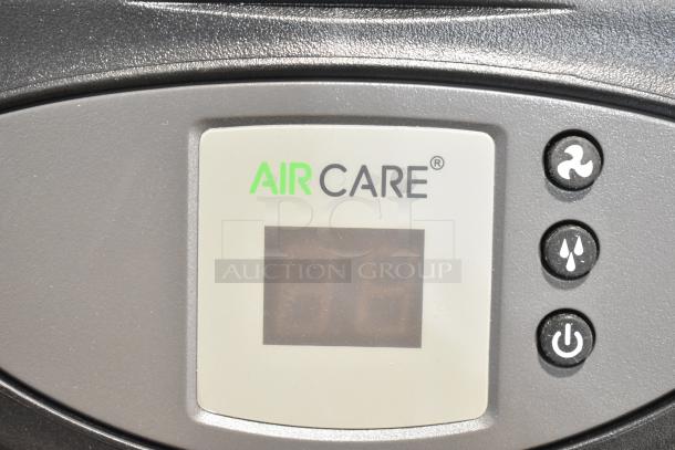 AirCare Fan control panel displaying brand logo, digital screen, and buttons for speed, humidity, and power functions.
