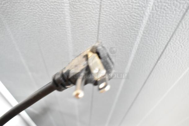 Blurred close-up of an electrical plug, associated with the Vissani MDTF14WH5 cooler/freezer. White textured background.