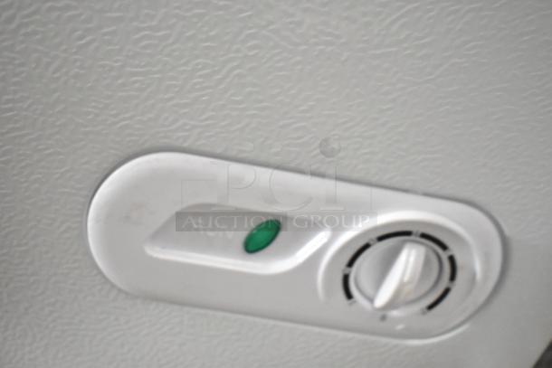 Alt text: Control panel of a Magic Chef HMCF5W4 chest freezer with "RUN" indicator and temperature dial.