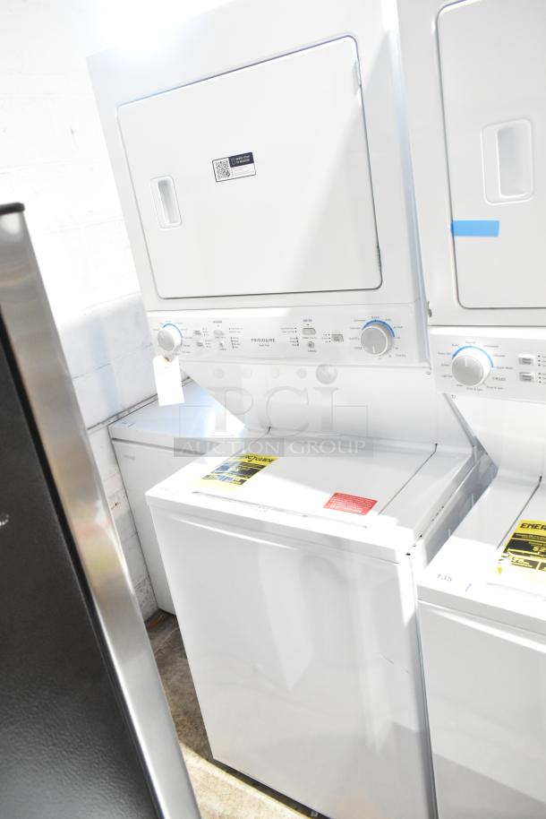 Brand new Frigidaire stacked top load washer and front load dryer with minor scratches and dents, visible tags indicate energy efficiency.