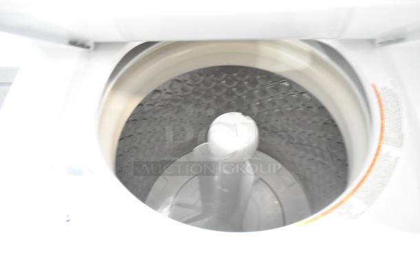 Frigidaire stacked washer with an open top view showing the inner drum and agitator, scratch and dent condition.