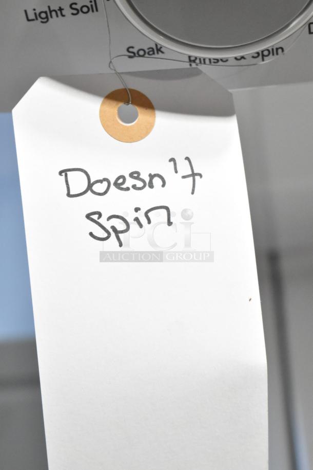 Frigidaire stacked washer and dryer, tag indicates washer "Doesn't Spin," brand new with scratches and dents.