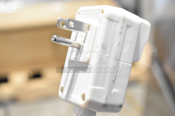 Close-up of a white plug from an LG LW1022IVSM window air conditioner. Visible metal prongs and minor surface wear.