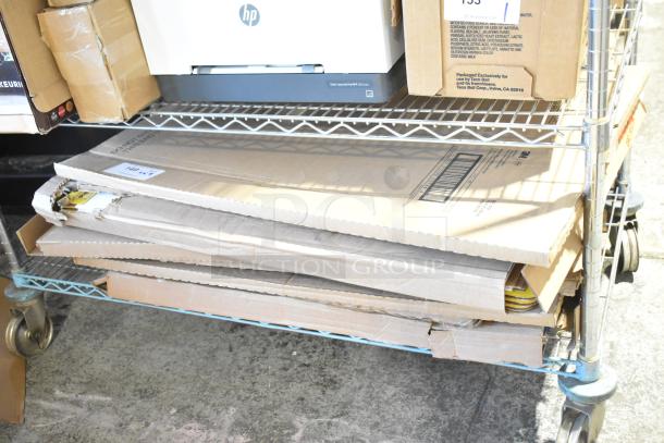 Nine boxes of 3M Easel Pad, Pacon Railroad Board, Pacon Presentation Board, and Super Value Poster, scratch and dent condition, on a metal cart.