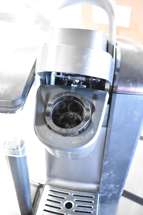 Keurig K-4550 single cup coffee machine, black, 120V, used condition, open pod compartment and drip tray visible.