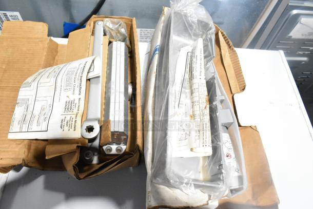 Box containing Ingersoll-Rand 4041 and Norton 1601 door closers, both in original packaging with manuals, appears in good condition.