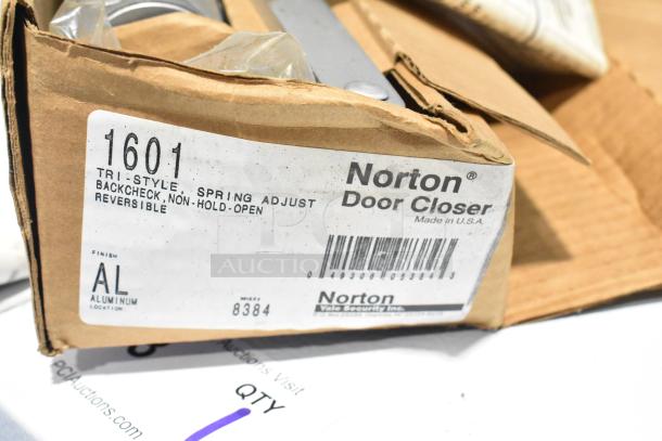 Box of various items, featuring Norton 1601 Door Closer with tri-style, spring adjust, backcheck, non-hold-open, reversible, aluminum finish.